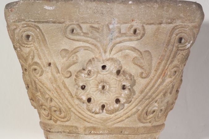 Capitello in pietra con fiore ad otto petali e altri motivi fitomorfi