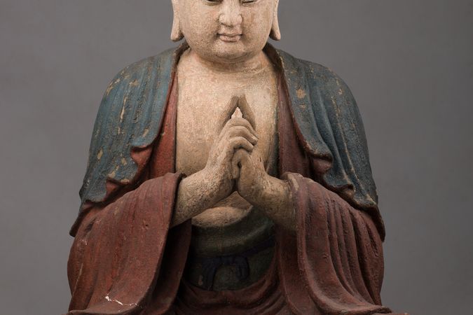 Buddha assiso a mani giunte