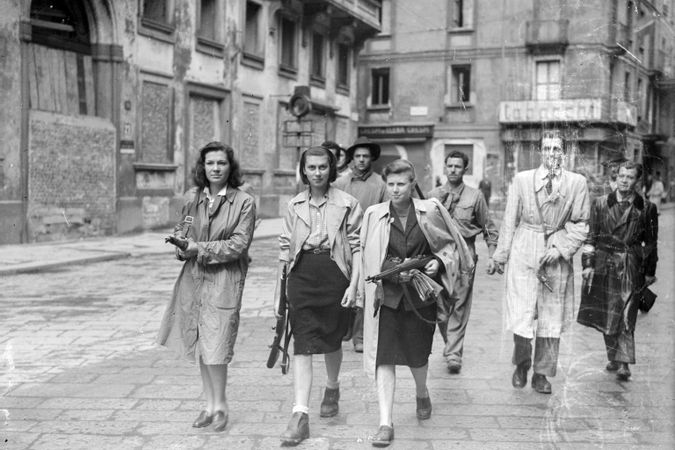 Tre ragazze, aggregate a gruppi di partigiani, in Piazza Brera mentre perlustrano la città insieme ai gappisti