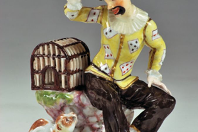 Arlecchino gioca con un uccello e con un gatto