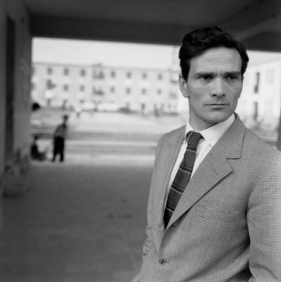 Pasolini sullo sfondo dei palazzi della borgata 