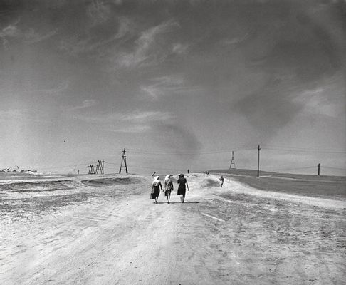 Donne in cammino in un paesaggio deserto