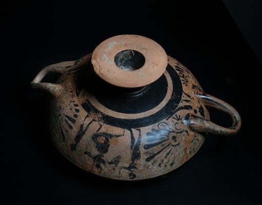 Kylix attica a figure nere con Nike alata tra due figure giovanili su un lato, tra un giovane e un vecchio barbato vestito di himation sull’altro tomba 1